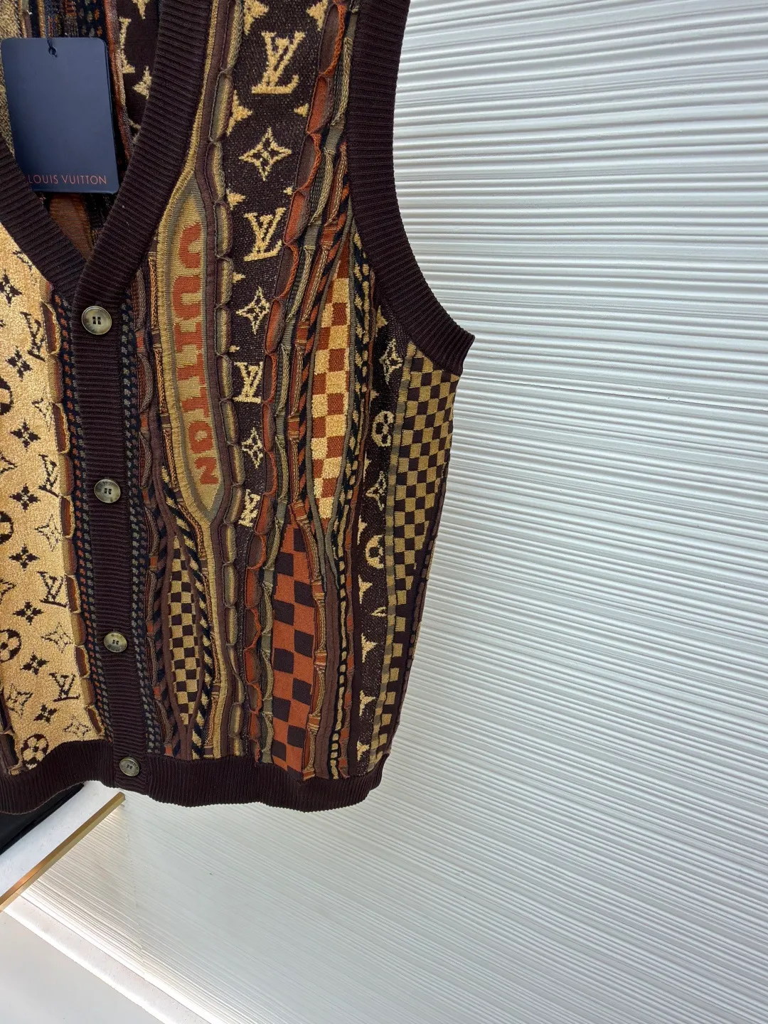 LOUIS VUITTON x Nigo jacquard knitted cardigan vest ●Original version: 13900 purchase and development ●Item number: 1681549-B45 ●Fabric: cotton fabric ●Technology: jacquard knitting ●Color: brown ●Version: fitted version ●Weight: about 330 grams ●Size: S-M-L-XL ●Description: This LOUIS VUITTON x Nigo FW25 This jacquard-knit cardigan vest has a loose fit for comfort and freedom of movement. The fabric is made of high-quality wool blend, with a soft and delicate feel, excellent warmth retention and breathability. The jacquard workmanship of the body is exquisite, with clear patterns and bright colors. It has remained firm and will not fall off after repeated washing tests. The neckline adopts a classic V-neck design, which fits the neck line and fastens tightly. The stitching on the body is even and neat, about 12 stitches per inch, ensuring a solid structure and not easily deformed. The cuffs and hem are ribbed to fit the body better while maintaining good warmth. The overall craftsmanship is exquisite and the details are well handled, reflecting the brand's strict control of quality. The combination of jacquard technology and wool blended material not only ensures the richness of the visual effect, but also enhances the overall texture and high-end sense. The overall wiring is straight and delicate, the fabric is comfortable and soft, and the color is consistent without color difference. It can be matched with the same style to create a fashionable look and control various occasions. Customized accessories, complete with three standards, same style for men and women!